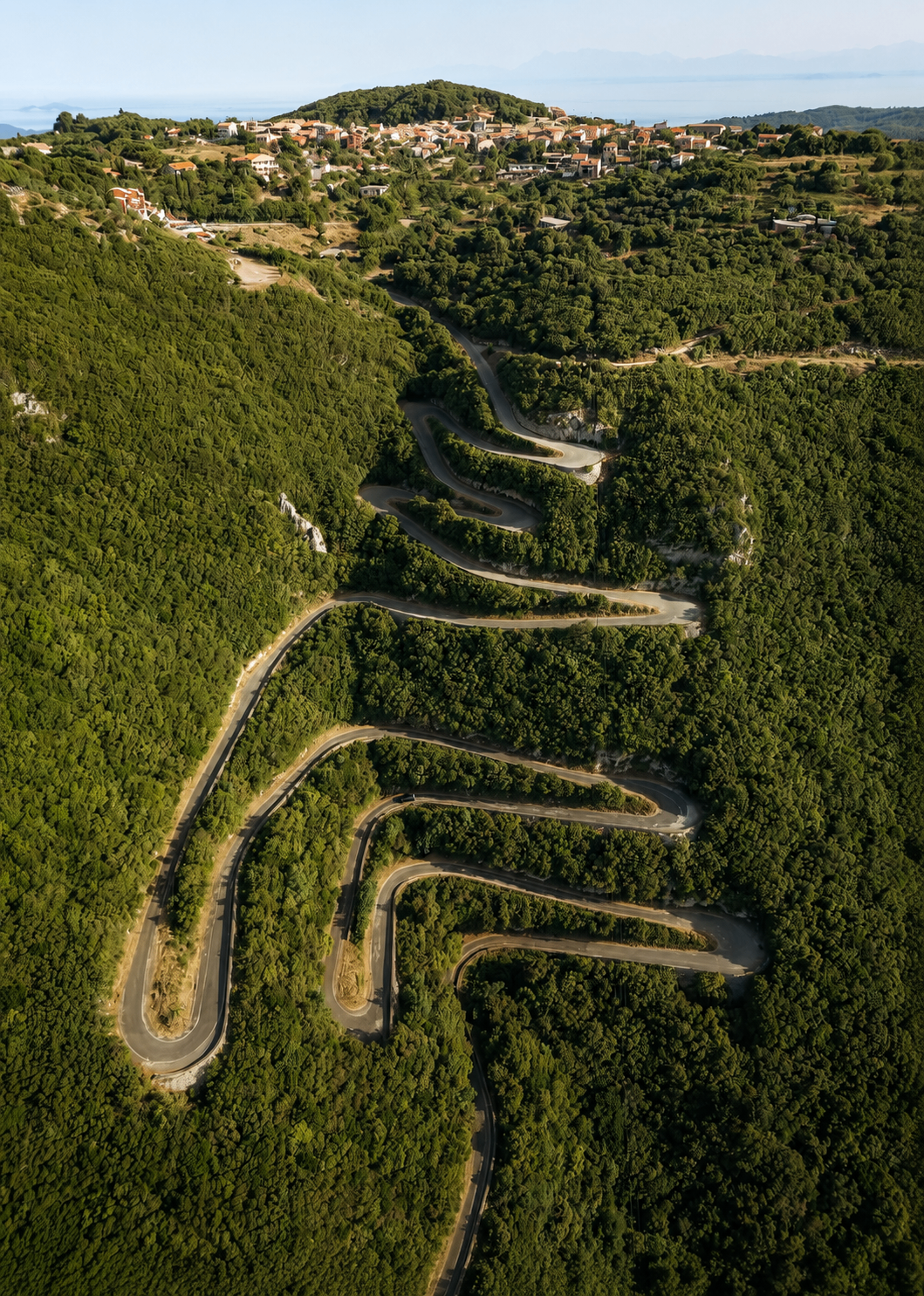 Winding mountain road through lush green Corfu hillsides