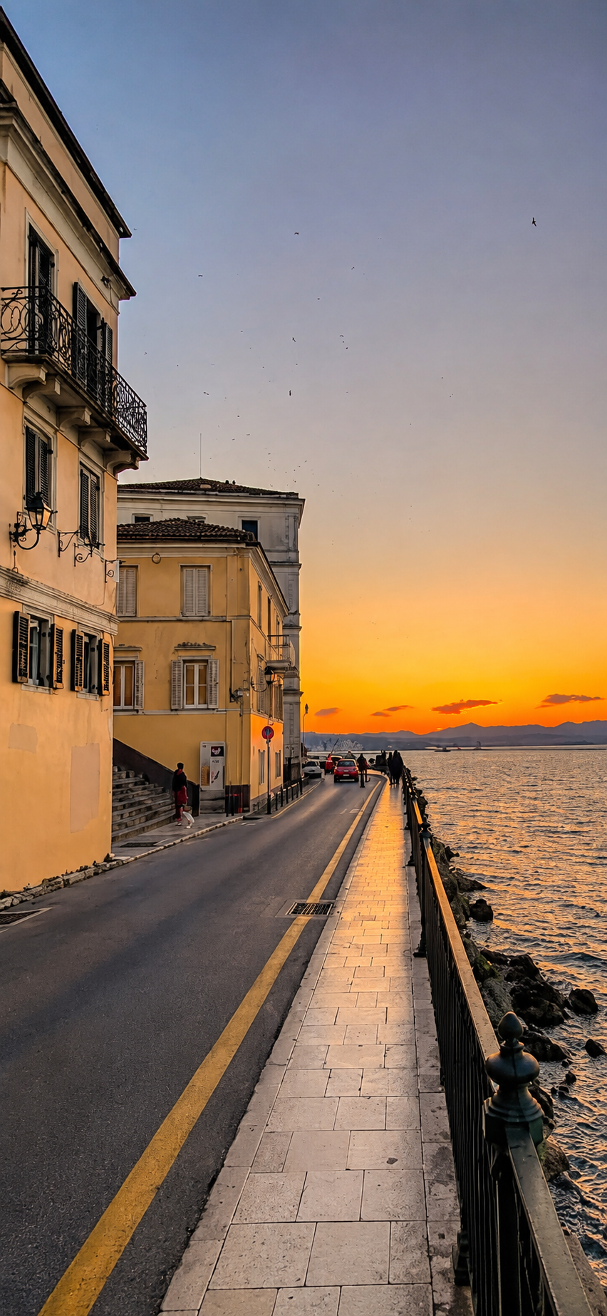Golden sunset over the Corfu seafront promenade